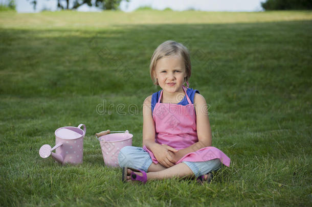 花园里拿着水壶的小女孩