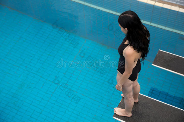 公共游泳池跳板上的女人
