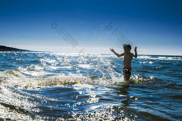 孩子的轮廓和海水的飞溅。暑假