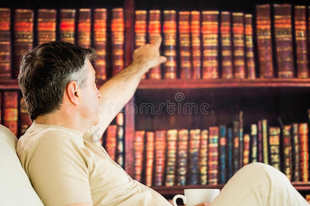 坐着的男人在<strong>阅览室</strong>里看书喝咖啡