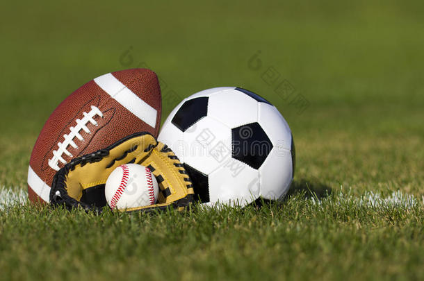 场上有码线的运动球。绿草地黄手套足球、美式足球和棒球