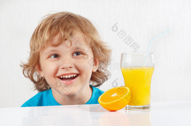 带着一杯新鲜果汁和橘子的微笑的小男孩