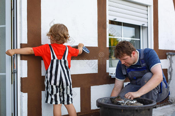 小男孩帮助他父亲装修房子