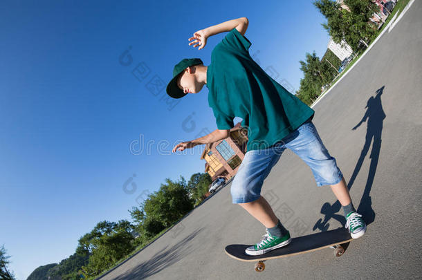 快乐的男孩在街上玩滑板。