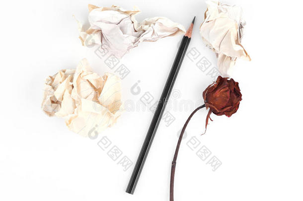 皱巴巴的旧纸和铅笔和枯萎的玫瑰