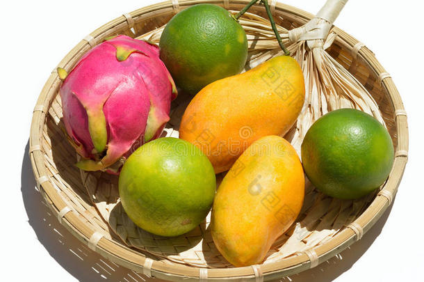 白色背景柳条盘上的新鲜热带水果