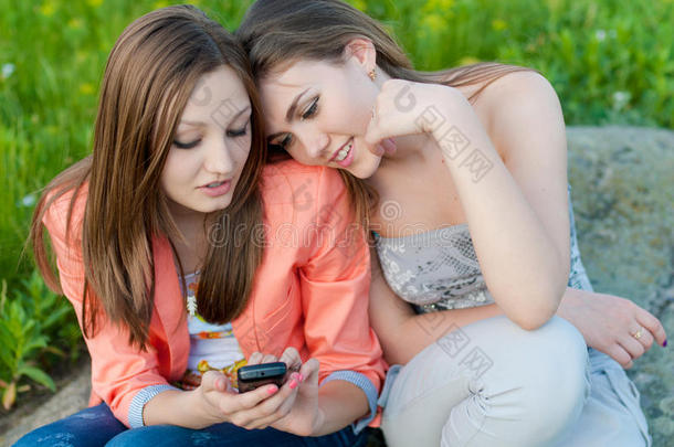 两个快乐的少女在手机上阅读信息