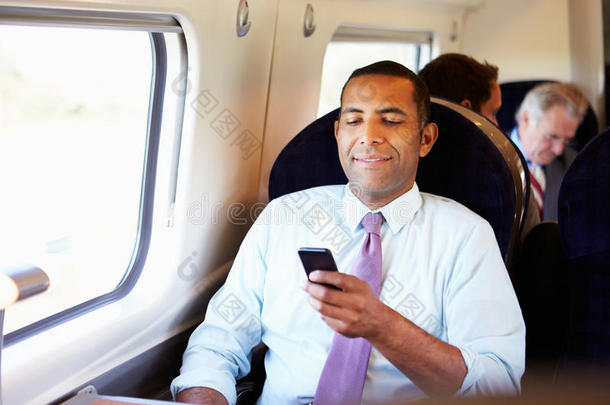 使用手机在火车上上班的商人