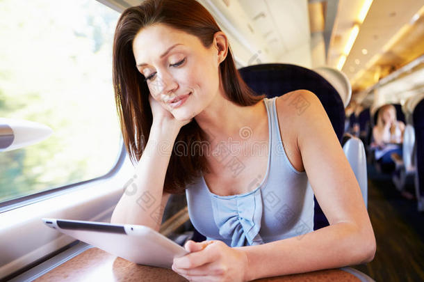在火车上使用数字平板电脑的妇女