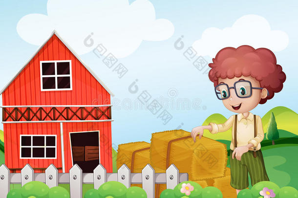 一个小男孩站在农场的干草堆旁