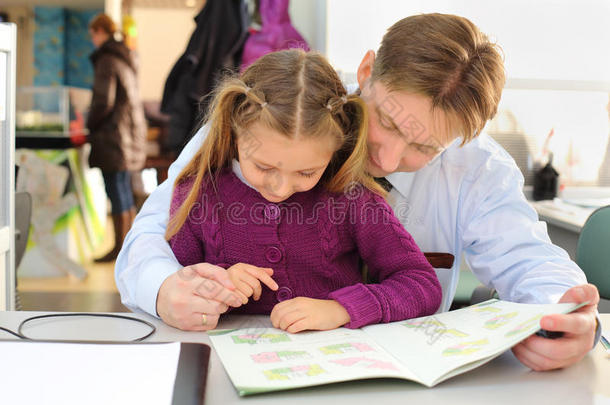 快乐女孩和她父亲在<strong>办公室</strong>看<strong>平面图</strong>小册子