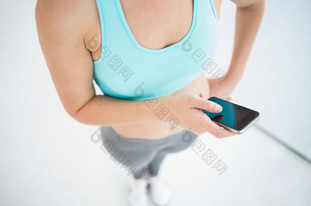 穿运动装的女人用她的智能手机