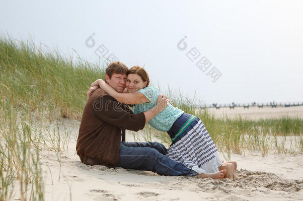 年轻幸福的恋爱情侣在沙滩上嬉戏