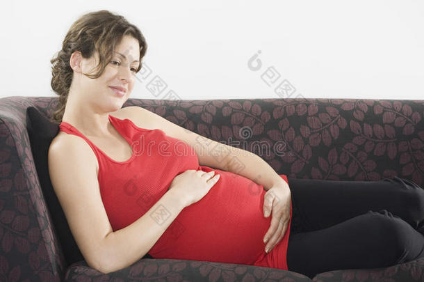 体贴的孕妇在沙发上放松