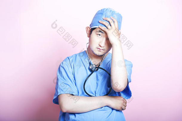 年轻的亚洲外科医生穿着紧身衣，看上去压力<strong>很大</strong>