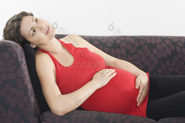 体贴的孕妇在沙发上放松