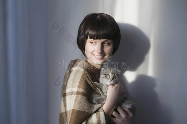 快乐的女人抱着小猫靠墙