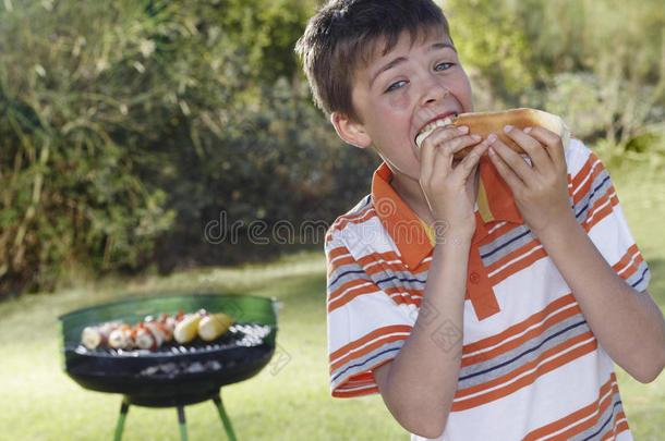 男孩吃法兰克福烤肉