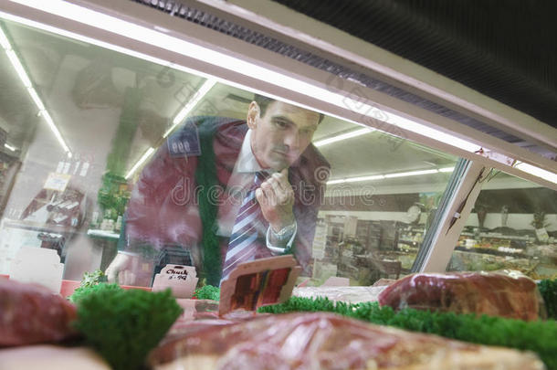 在超市里看肉的男人