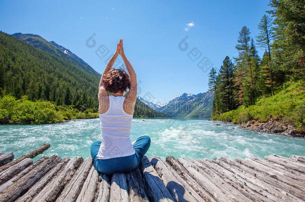 年轻女子在山河练瑜伽