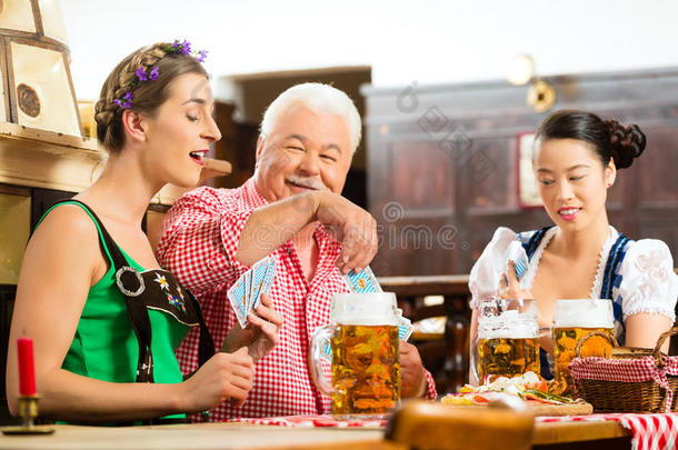 朋友们在巴伐利亚酒吧喝啤酒打牌