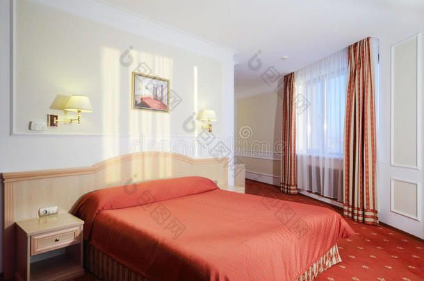 带红色亚麻布和红地毯的<strong>双人床</strong>的简单卧室