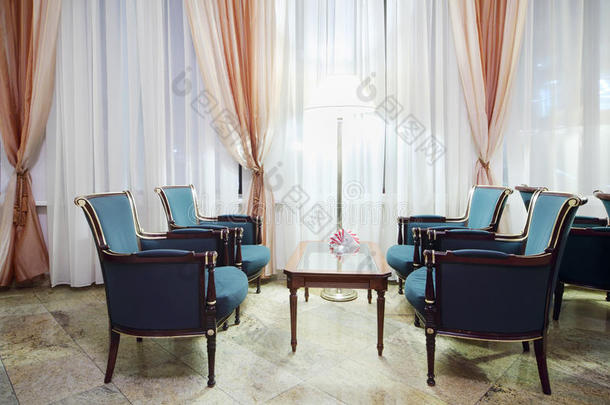舒适的房间，有桌子、绿色椅子和大窗户