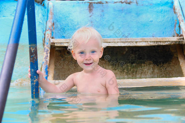 快乐微笑的小男孩在<strong>游泳池</strong>里下水