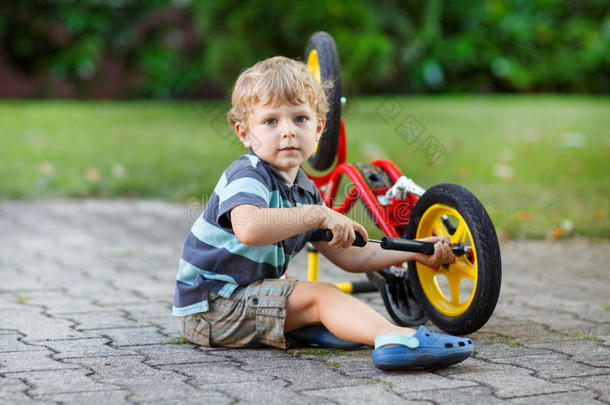 小男孩<strong>正在修理</strong>他的第一辆自行车