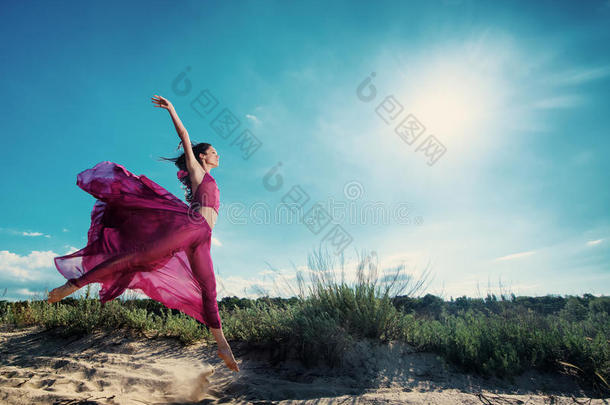 穿着通风衣在海滩上跑步的女人