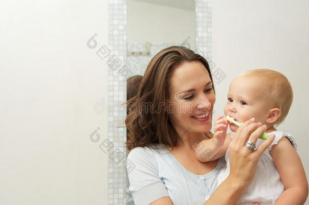 微笑的妈妈教可爱的宝宝如何用牙刷刷牙