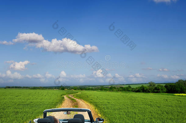 穿过田野的乡间小路上的白色敞篷车