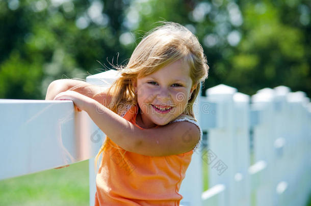在白色篱笆上微笑的孩子