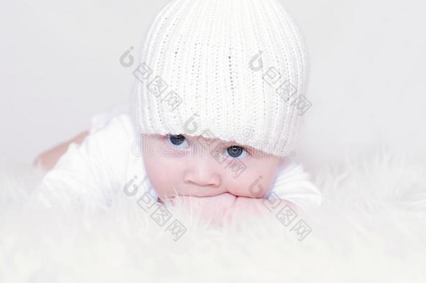 戴着白色针织帽的伤心婴儿