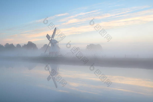 日出时浓雾中的荷兰风车