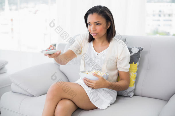 严肃的黑发白衣女子一边吃爆米花一边换电视香奈儿