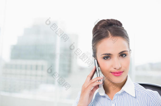 微笑的黑发女商人用智能手机打电话
