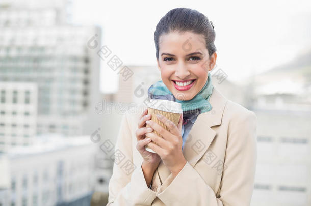 笑容可掬的棕色头发女商人端着一杯咖啡