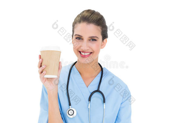 快乐的棕色头发护士，穿着蓝色的衣服，端着一杯咖啡