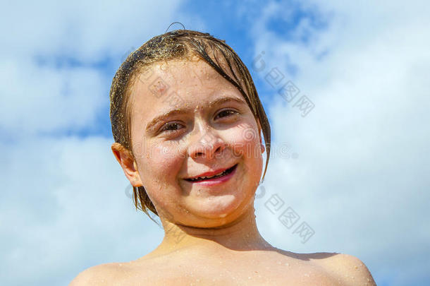 一个满脸笑容、头发湿漉漉的男孩的画像