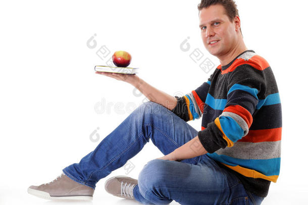 一个男人拿着一本书和一个红苹果