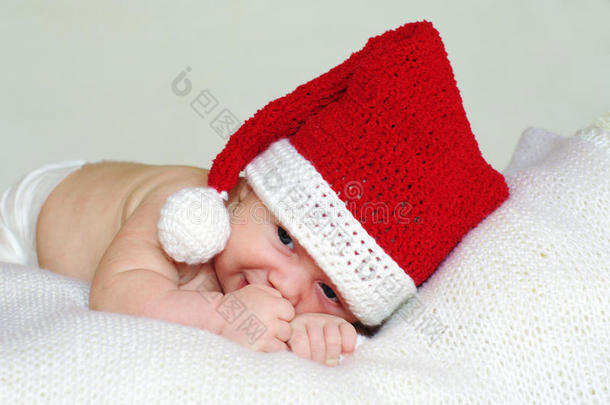 戴着红礼帽的2个月大的悲伤宝宝