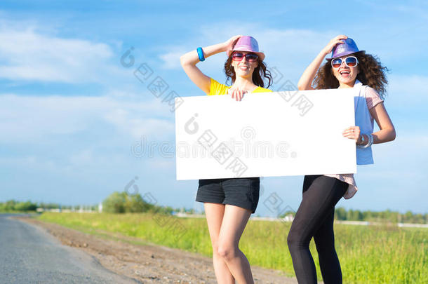 两个年轻女子举着一面空白的横幅站着