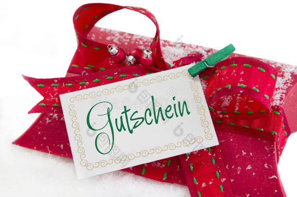 红色礼品盒和优惠券的特写，带有德国文字的圣诞礼物