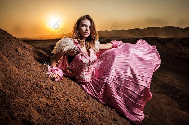 <strong>迷人</strong>的<strong>浪漫</strong>女人穿着漂亮的粉色连衣裙在户外摆姿势。