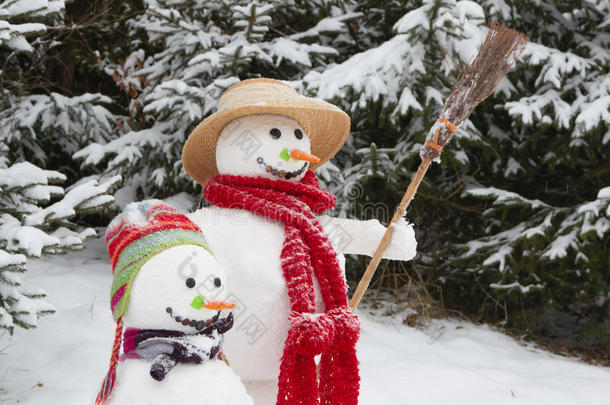 冬季-雪景中的两个雪人带着帽子和c
