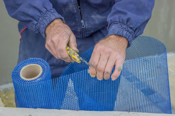 建筑工人用切割机切割塑料格栅