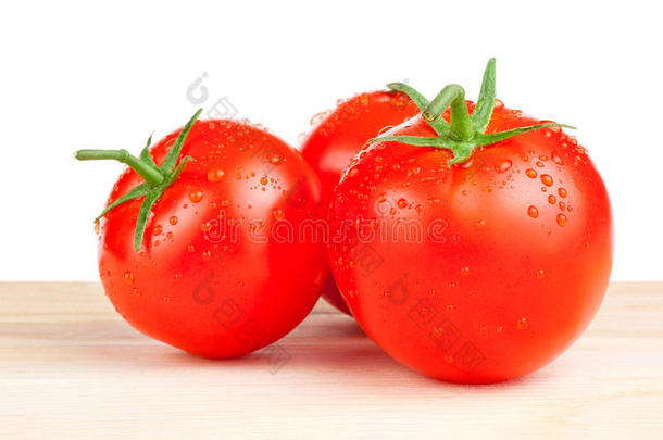 三个潮湿的西红柿<strong>放在</strong>砧板上，白色背景下的<strong>木质</strong>隔离物