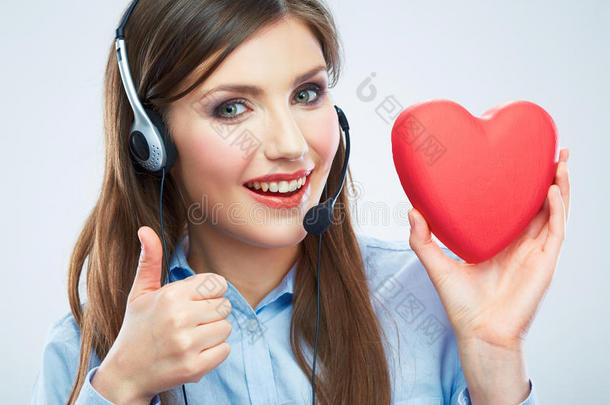 女呼叫中心接线员手持爱心象征红心。闭合