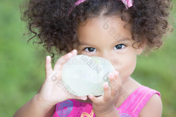 有趣可爱的拉丁女孩用<strong>奶瓶</strong>喝水